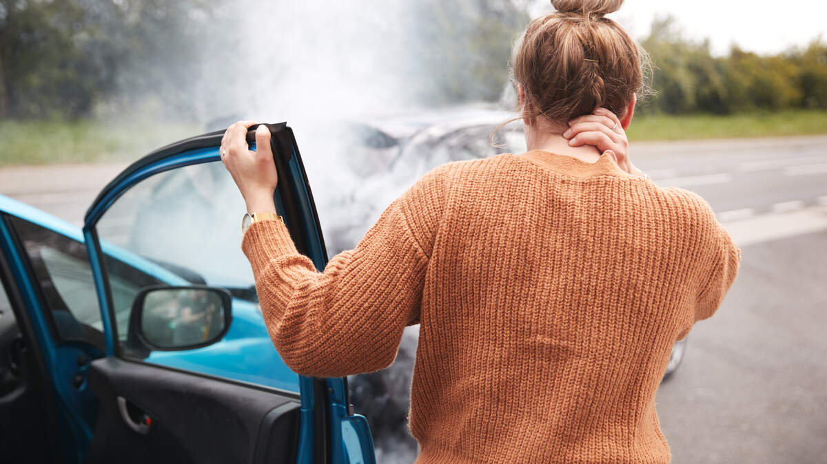 Female Motorist With Head Injury Getting Out Of Car After Crash