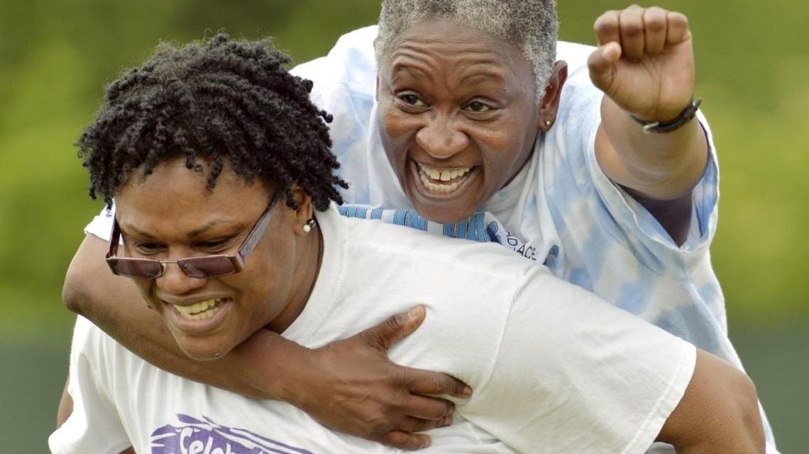 Travis Crawford with team “Oh Lordy Girls” carries her teammate Angela Mock during the final leg of a dizzy bat relay during the 2014 Adult Field Day.