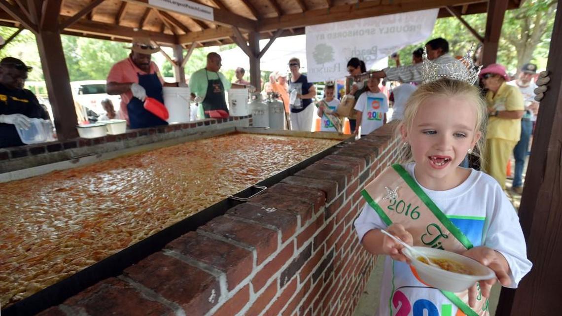 Bella Grace Sanders of Forsyth, the 2016 Tiny Miss Georgia Peach, gets a sample of the 800-pound peach cobbler at last year’s Peach Festival in Fort Valley.