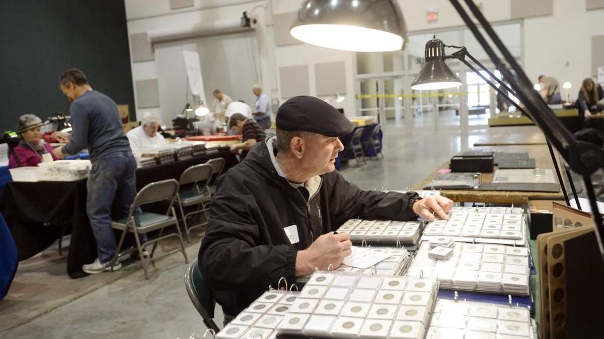 Dean McConnell, of Warner Robins, looks through a selection of modern proofs at the Middle Georgia Coin Club’s 2014 Coin & Currency Show.