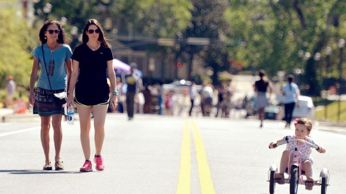 Caitlan Bush, 3, rides her tricycle on College Street during Open Streets Macon in 2015.