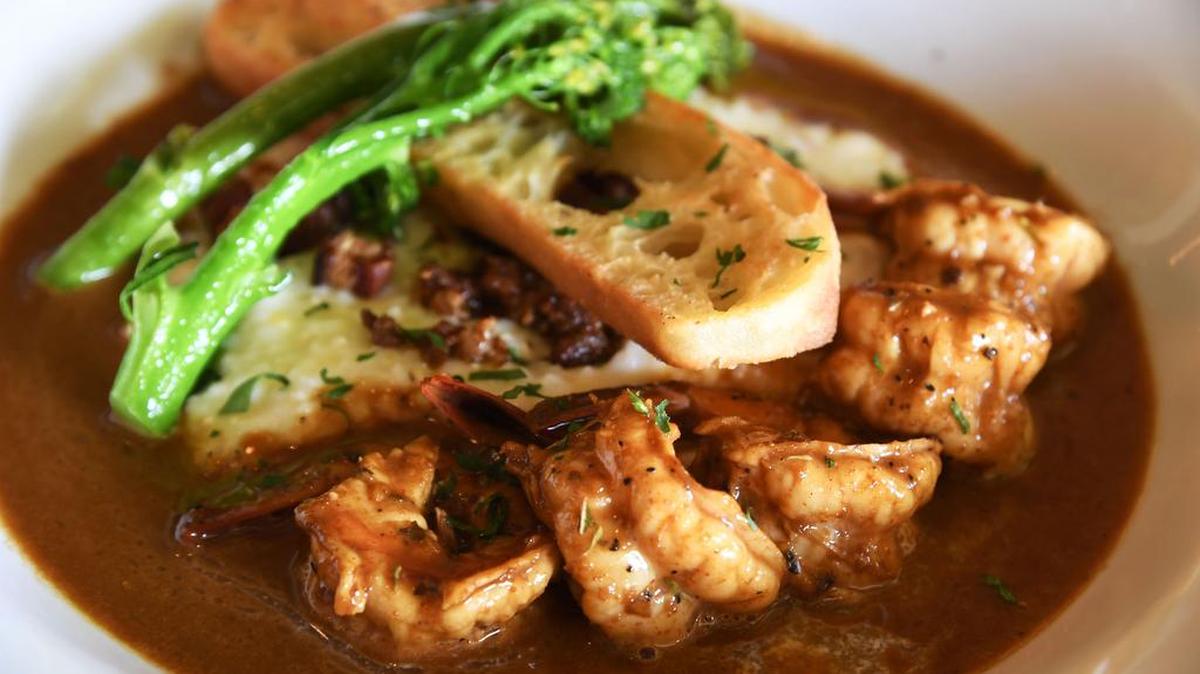 New Orleans barbecue shrimp and grits smokehouse gouda grits, house made Andouille and bacon, parsley, grilled ciabatta make for an excellent dish at Grits Cafe.