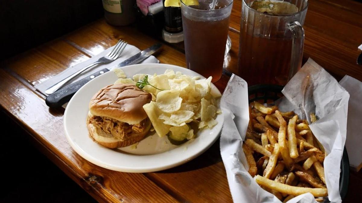 A barbecue sandwich with chips and a side of hand cut french fries Satterfield’s. Kids’ menu items include piglet sandwiches, turkey “goblets,” ham “hamlets,” grilled cheese, pink lemonade and banana pudding.