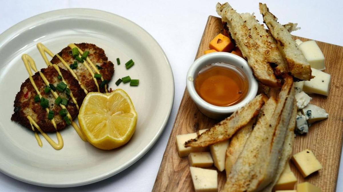 Crab cakes and a cheese board with five different cheeses and bread strips and honey are among the choices at the Downtown Grill.