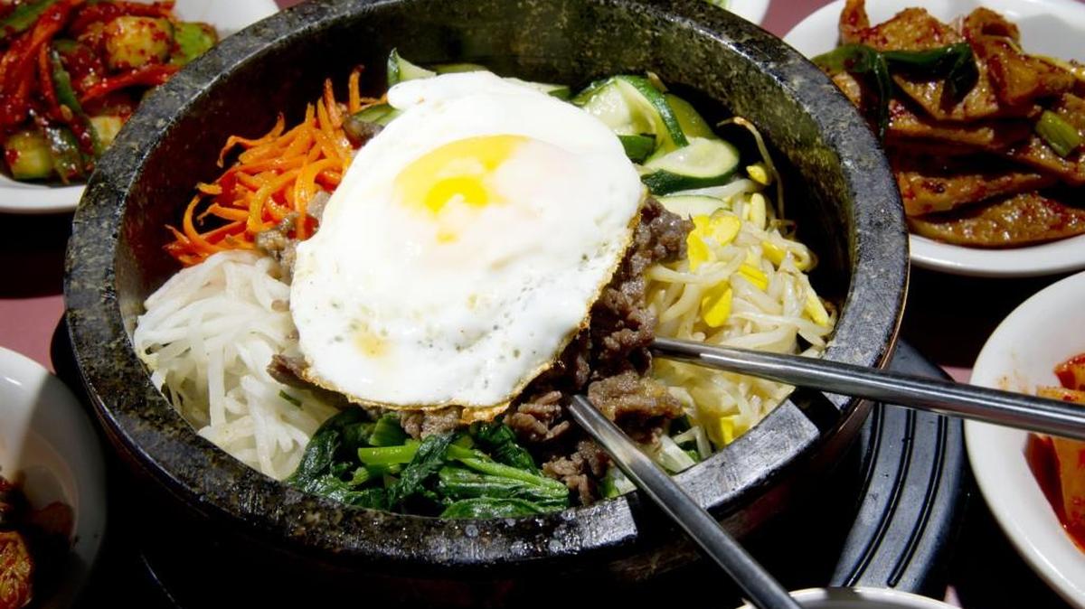 Bibimbap, a signature Korean dish, is cooked in a hot stone pot and served with a fried egg at Kum O Jung.
