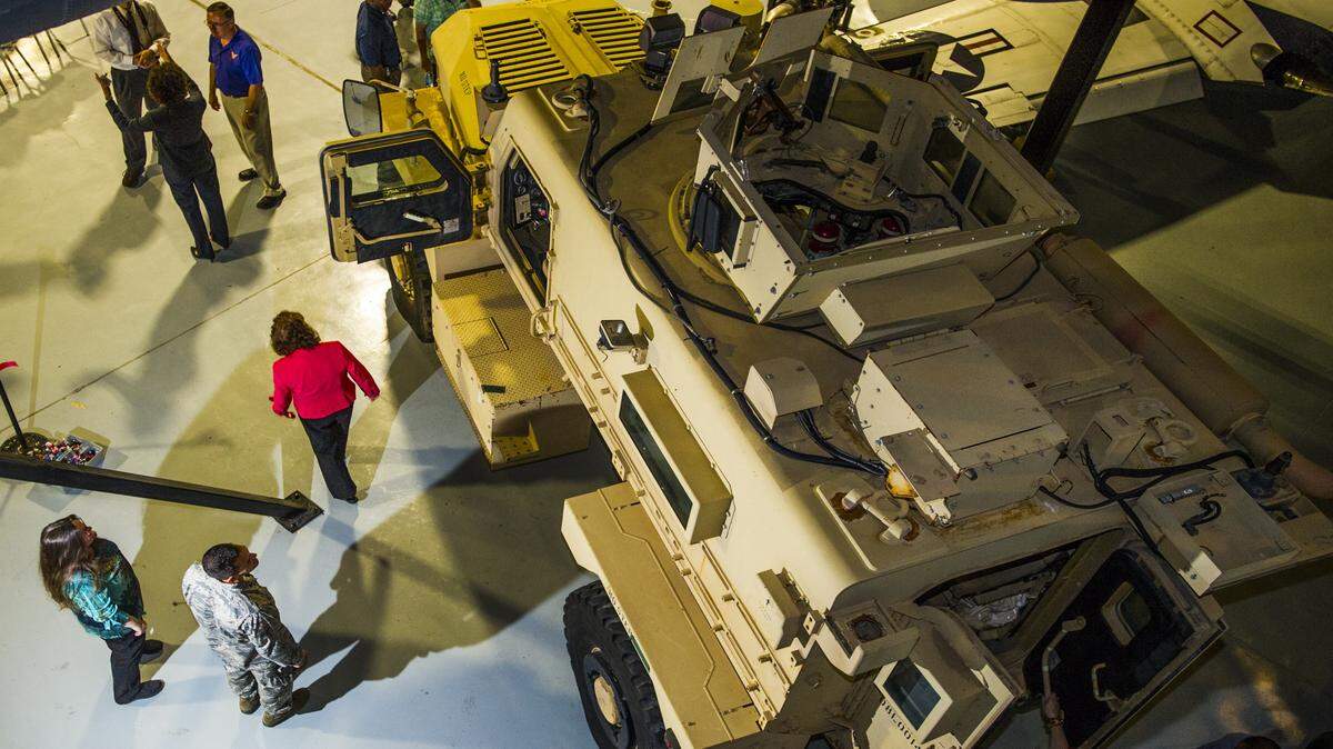 People get a closer look at the Cougar A2 CAT 1 Mine Resistant Ambush Protected Vehicle displayed in the Century of Flight building at the Museum of Aviation after its ribbon cutting ceremony Wednesday.
