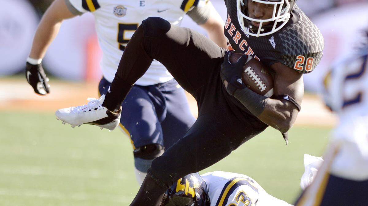 Mercer running back Tee Mitchell (28) is tripped up after a first down run by ETSU safety Cole West during their game Saturday.