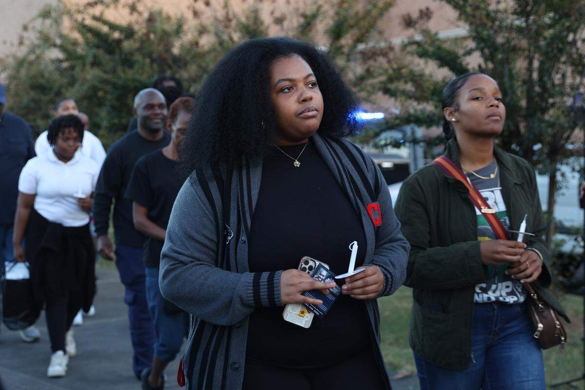 Clark Atlanta University third year student Essence Winters hold a candle while walking in front of the Bibb County Jail during a candlelight vigil for Stephen Fossett on Tuesday, Oct. 22, 2024, in Macon, Georgia. Family, community members and lawyers used the vigil to call for change and to release the body cam footage from the jail. Fossett’s death was ruled a homicide earlier this month. 