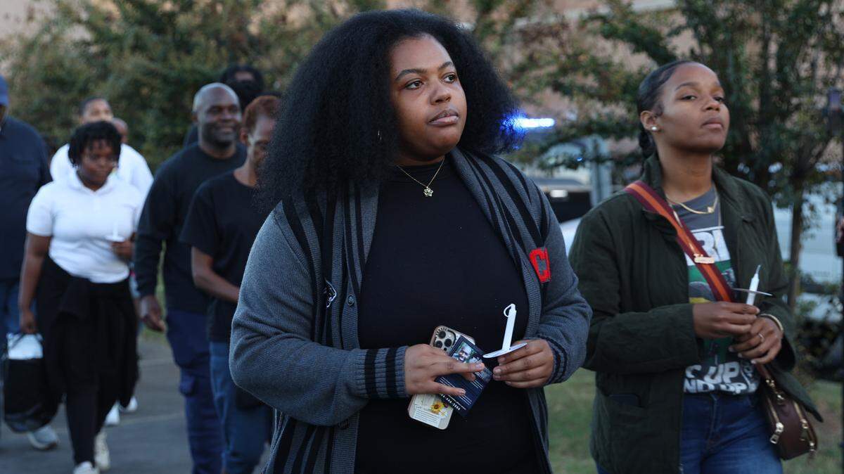 Clark Atlanta University third year student Essence Winters holds a candle while walking in front of the Bibb County Jail during a candlelight vigil for Stephen Fossett on Tuesday, Oct. 22, 2024, in Macon, Georgia. Family, community members and lawyers used the vigil to call for change and to release the body cam footage from the jail. Fossett’s death was ruled a homicide earlier this month.