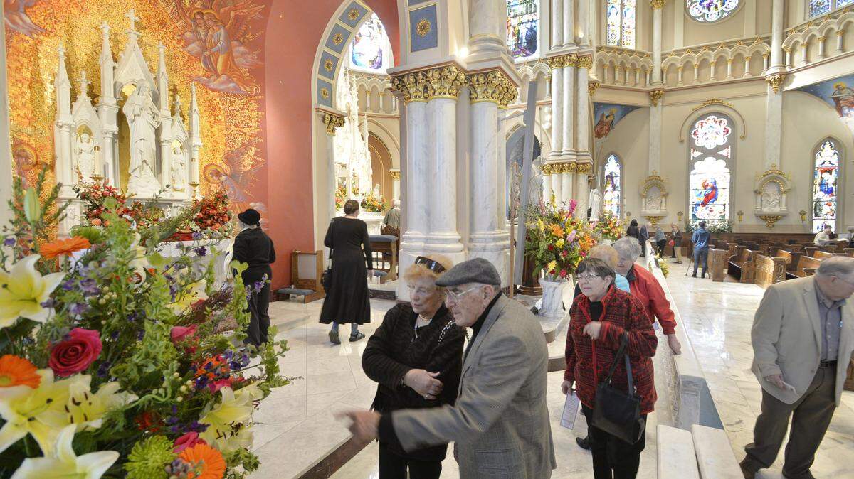 Connie and Jack Menendez (center) enjoy flower arrangements at St. Joseph Catholic Church during the fifth annual Old City Flower Festival running through Jan. 20th.