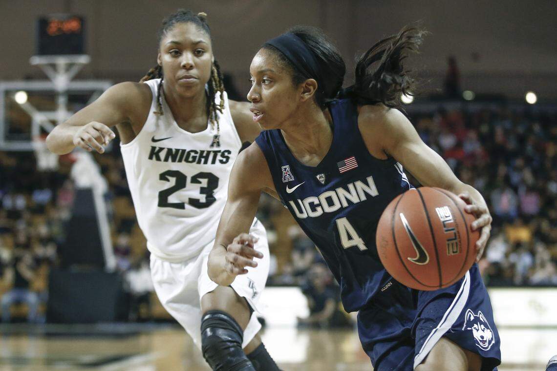 Connecticut guard Mikayla Coombs (4) drives past Central Florida guard Lawriell Wilson (23) during the second half of an NCAA college basketball game in Orlando, Fla., on Sunday, Feb. 17, 2019. (AP Photo/Reinhold Matay)