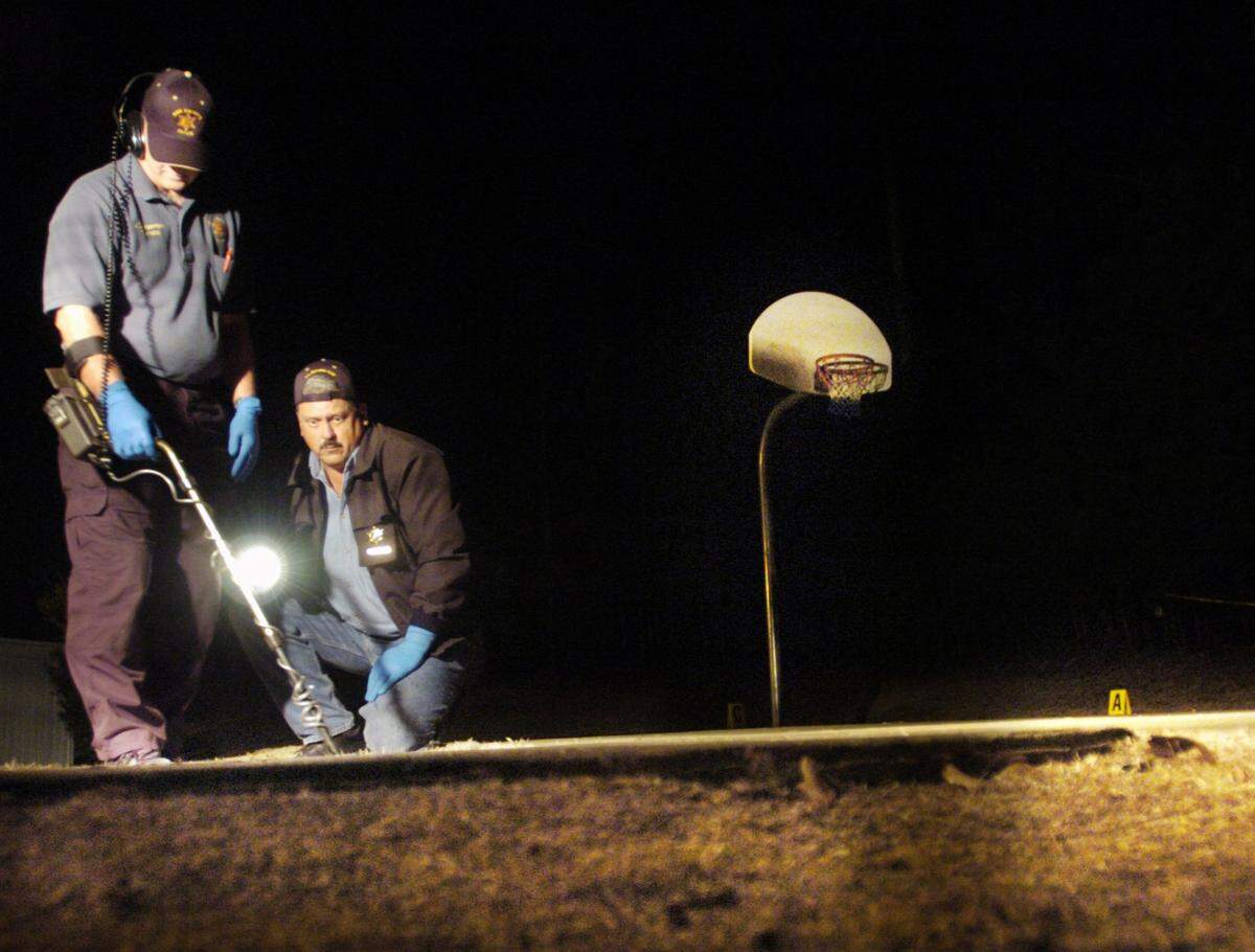 Bibb County sheriff’s deputies search for bullets at the scene of a 2004 shooting at Oak Ridge Apartments near Riverside Drive.