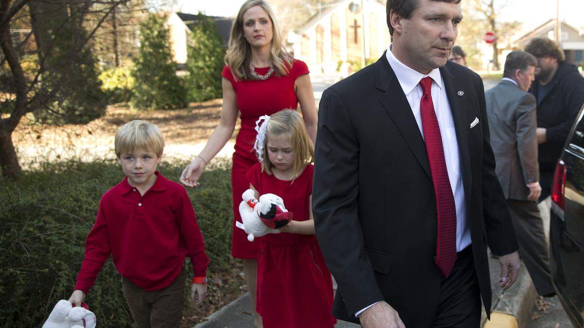 Alabama defensive coordinator Kirby Smart is followed by his wife Mary Beth and seven-year-old twins Westin and Julia to a waiting car after a press conference where he was introduced as Georgia's new NCAA college head football coach Monday, Dec. 7, 2015, in Athens, Ga. Smart will continue in his current role as Alabama's defensive coordinator through the College Football Playoff as he also begins work as Georgia's coach. (AP Photo/John Bazemore)