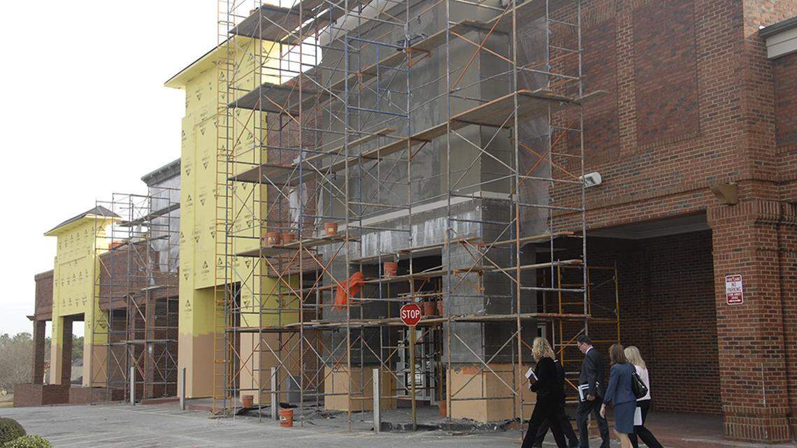 People walk past the entrance of the former Publix in Warner Robins, where work is going on to prepare the center to become a training and research facility for the Air Force.