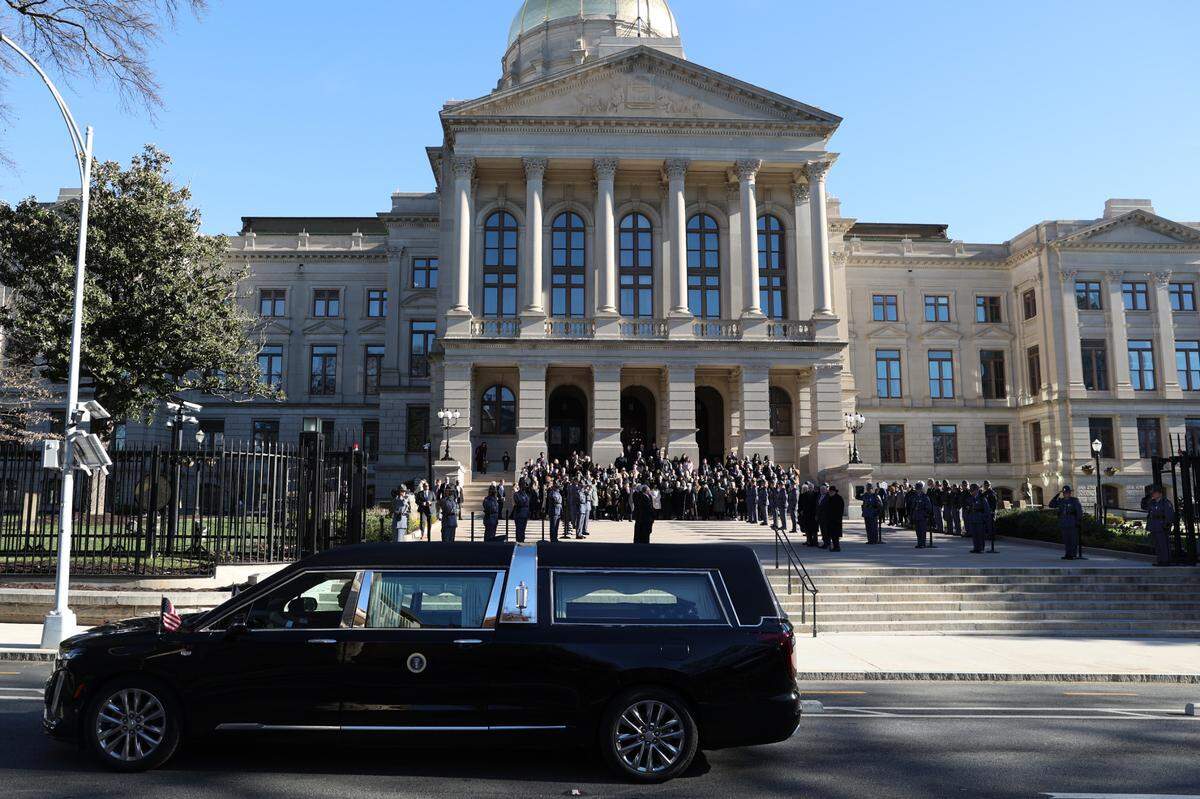 A hearse carrying former President Jimmy Carter pauses in front of the Georgia State Capitol on Saturday, Jan. 4, 2025. Politicians gathered in front of the Capitol as the motorcade drove from Plains to Atlanta.