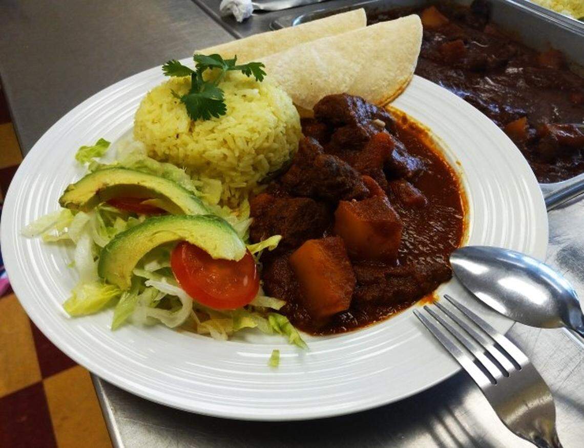 Steak in chili sauce with potatoes and carrots served with white rice and a side salad of lettuce, tomatoes and avocado at El Ranchito in Warner Robins