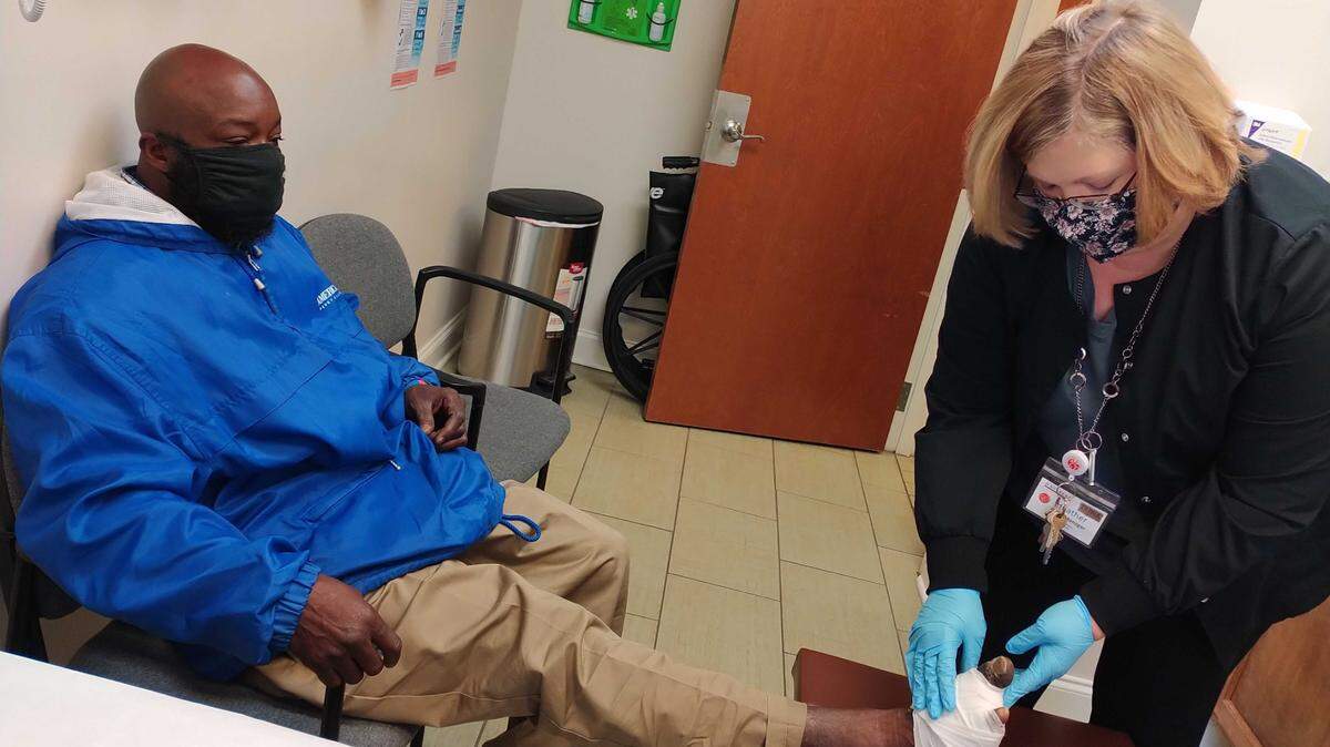 Calvin Taylor, left, gets the bandage on his foot changed by Heather Sostarich, clinic manager at Daybreak.