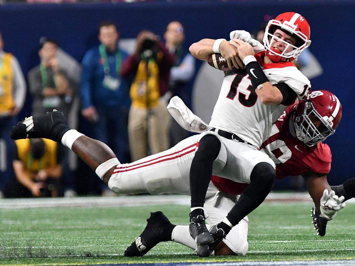 Georgia quarterback Stetson Bennett (13) is brought down by Alabama’s Phidarian Mathis (48) Saturday during the SEC Championship.