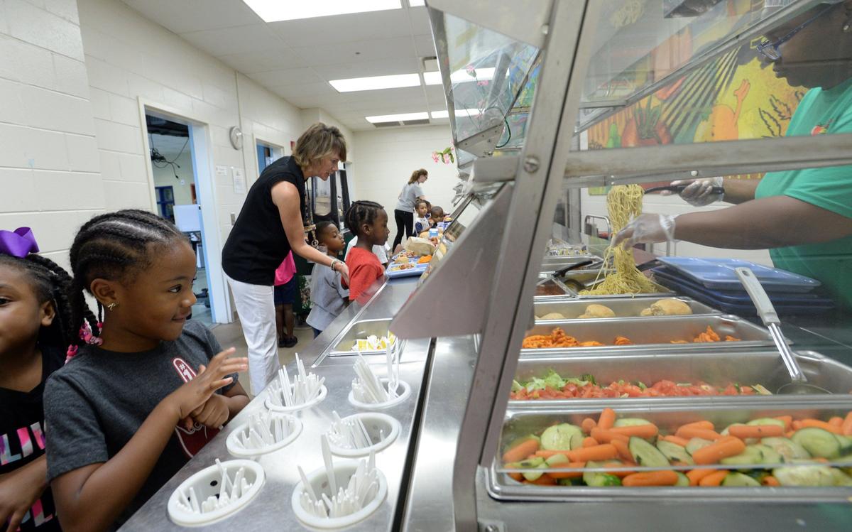Alexander II Magnet School kindergartener Rylee Davis, left, says she loves spaghetti as she goes through the lunch line.