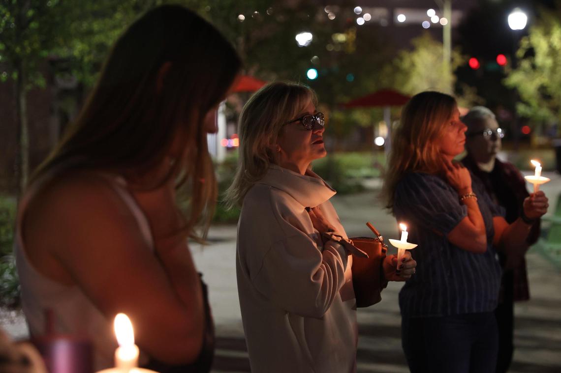 Attendees feel their heartbeat as organizer Scott Mitchell speaks during a candlelight vigil hosted in the Cotton Avenue Plaza on Tuesday, Nov. 12, 2024, in downtown Macon, Georgia. Rather than honoring the life of someone who has passed, organizers said that the vigil was an opportunity for members of the LGBTQ+ community and allies to gather following the results of Election Day a week prior.