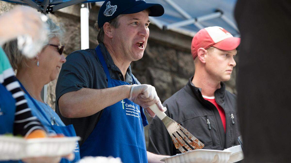 Supreme Court Justice Brett Kavanaugh, center, serves meals to the homeless as he volunteers with Catholic Charities on Wednesday in Washington.
