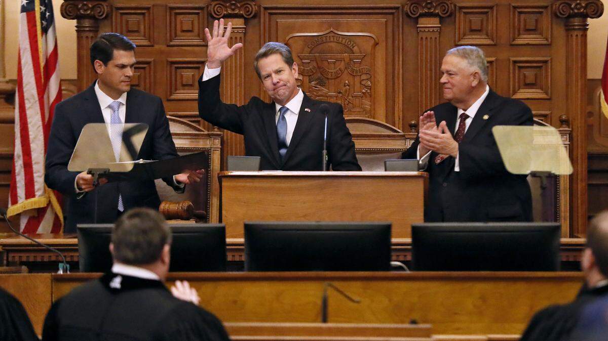 Georgia Gov. Brian Kemp, center, flanked by Lt. Gov. Geoff Duncan, left, and House Speaker David Ralston, receives applause after he delivered his first State of the State address Thursday in Atlanta.