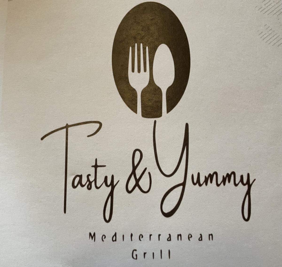 Tasty & Yummy Mediterranean Grill logo on the front of the menu.
