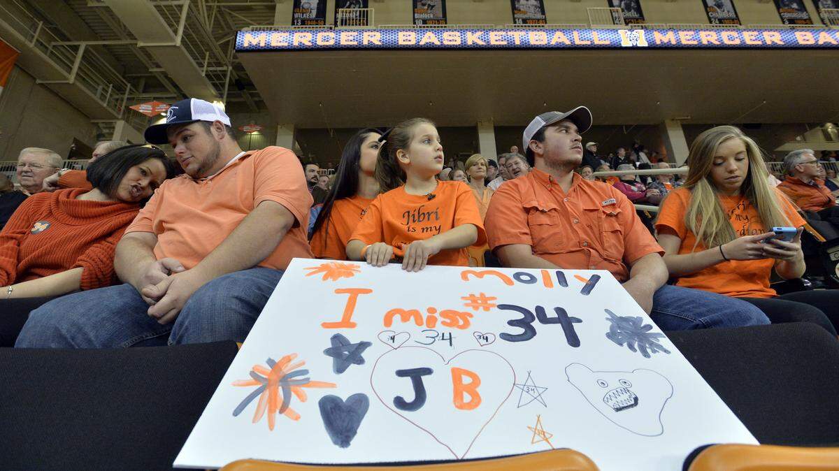 Molly Hamlin, 7, holds a sign she said she made to express solidarity' with her favorite team's players Saturday before the game against The Citadel.