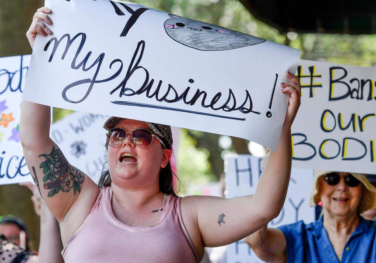 Event organizer Lacey Albritton chants ““Hey Hey Ho Ho, your backward views got to go,” as she marches with hundreds down Cherry Street during a pro-choice march and rally Sunday in downtown Macon.
