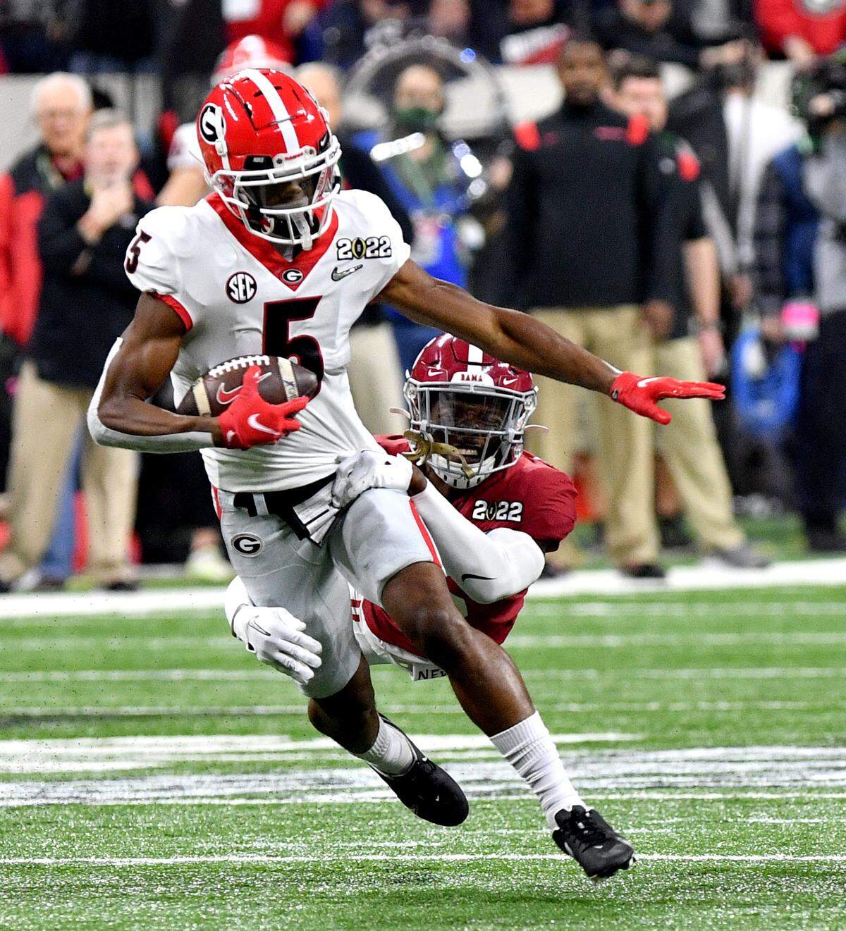 Georgia receiver Adonai Mitchell (5) hauls in a first down reception from quarterback Stetson Bennett (13) during the Bulldogs’ College Football Playoff National Championship game against Alabama Monday night.