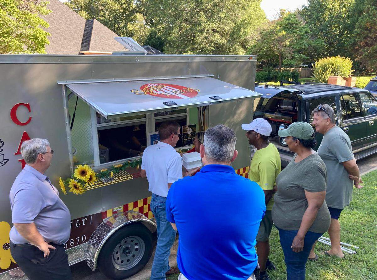 People line up at the Signature Flavors Cafe & Catering food truck at The Brantley subdivision Wednesday in Warner Robins.