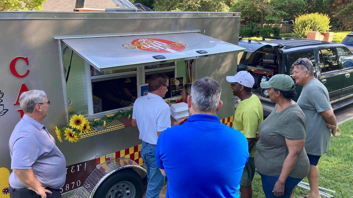 People line up at the Signature Flavors Cafe & Catering food truck at The Brantley subdivision Wednesday in Warner Robins.