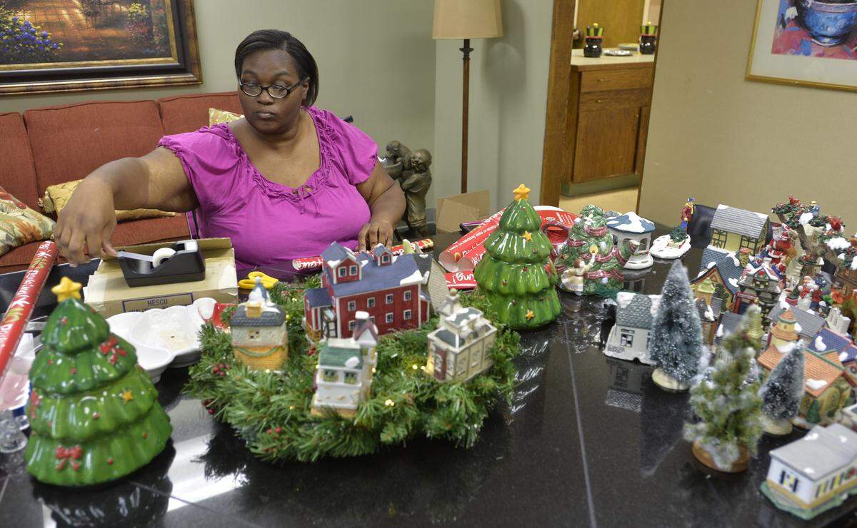 Debra Hughes wraps Christmas presents for the needy at the Mentors Project headquarters.