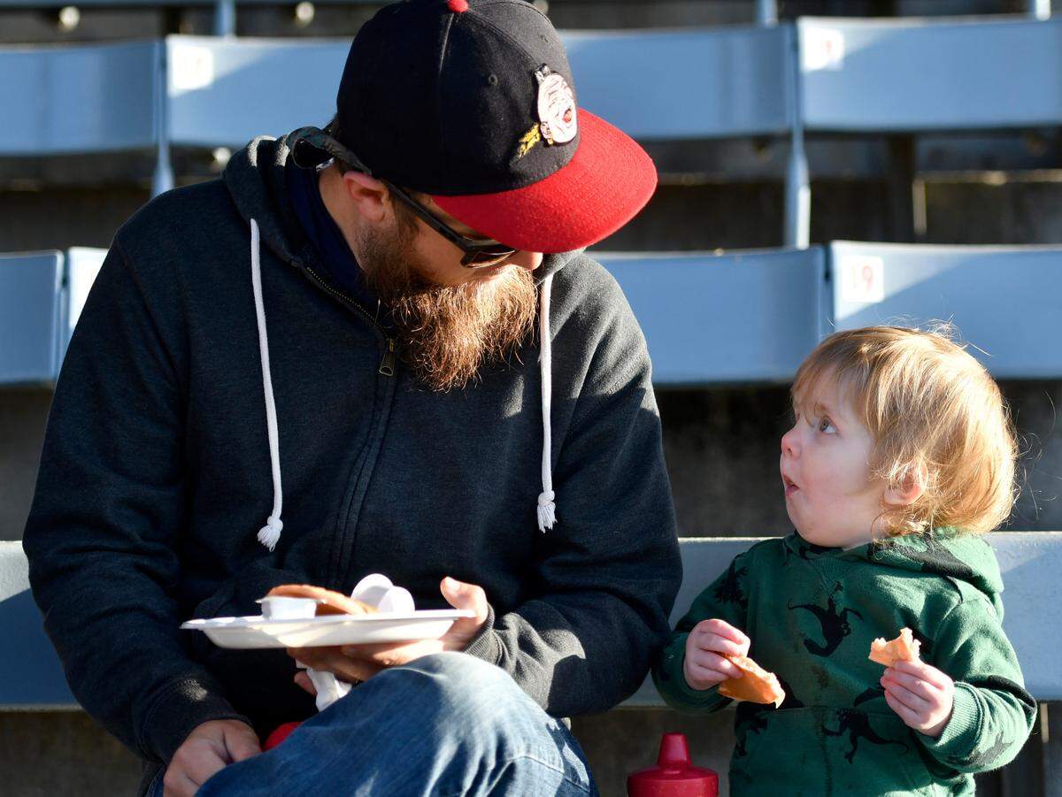 Christopher Mullis and his son Denver, 2, enjoy pancakes and bacon Saturday morning during the Cherry Blossom Festival Pink Pancake Breakfast at Luther Williams Field.