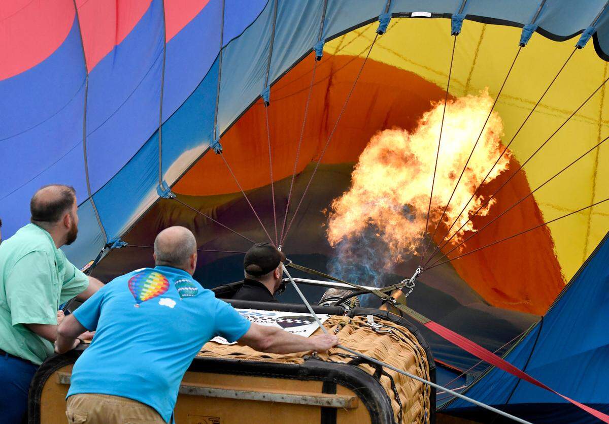 A crew attempts to lift a hot air balloon Sunday night as winds made it impossible for the balloon glow during the Cherry Blossom Festival Tunes and Balloons finale at Middle Georgia State.