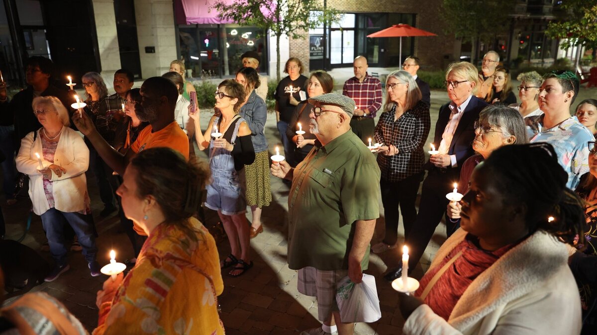 Attendees listen to Scott Mitchell during a candlelight vigil in the Cotton Avenue Plaza on Tuesday, Nov. 12, 2024, in downtown Macon, Georgia. Rather than honoring the life of someone who has passed, Mitchell said that the vigil was an opportunity for members of the LGBTQ+ community and allies to gather following the results of Election Day a week prior.