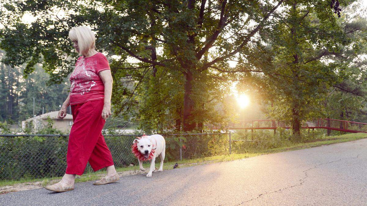 Alison Caruso walks her dog Molly along the Wellston Trail in Warner Robins Thursday morning. Caruso moved from New Orleans to Warner Robins 10 years ago after Hurricane Katrina.