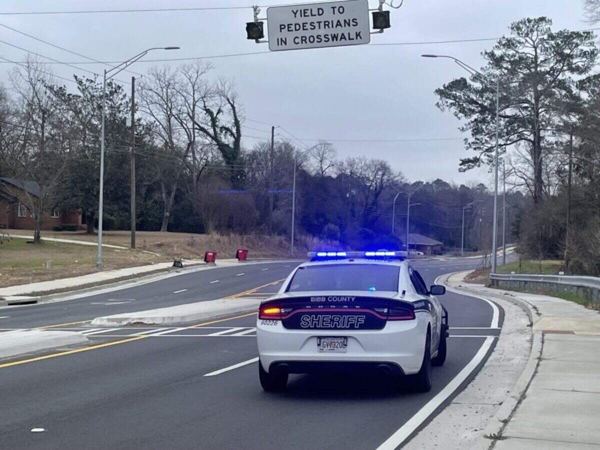 A Bibb County sheriff deputy’s car with blue lights activated near a pedestrian crosswalk on Jeffersonville Road in Macon.