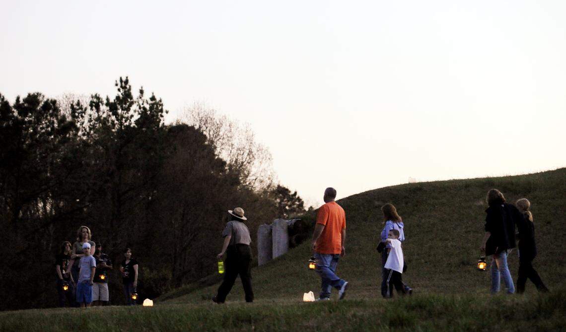 Guest walk near the Earth Lodge at the Ocmulgee National Monument during a guided lantern tour in 2011.