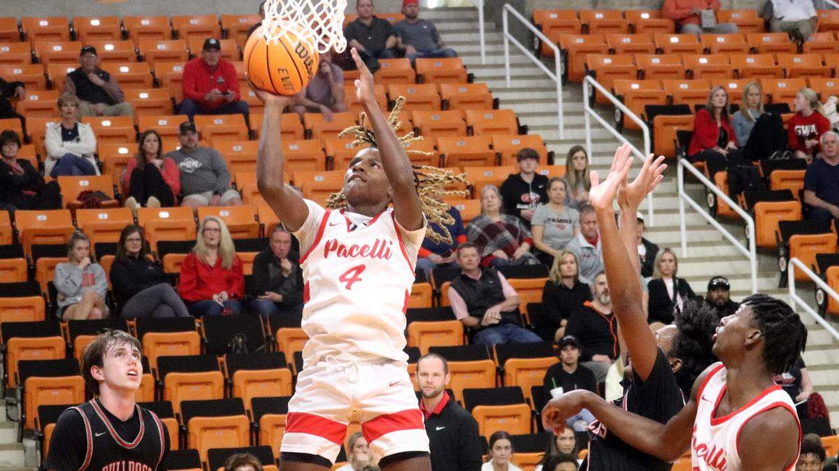 St. Anne-Pacelli guard T.J. Smith (4) shoots the basketball over George Walton defenders Thursday night. The Vikings won 72-48 to advance to the GIAA 4A Championship Saturday night.