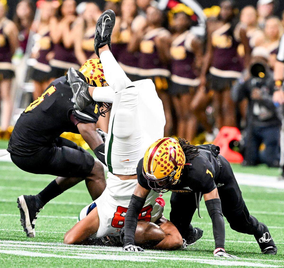 Stockbridge tight end Tyler Tucker (88) is upended by Perry defenders during the second half of their GHSA 4A State Championship game Tuesday in Atlanta.