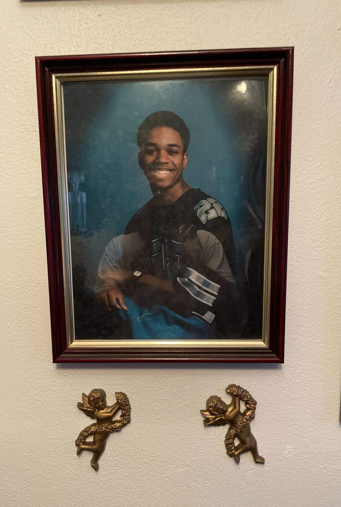Framed photo of Jessie James Askew Jr. in his early 20s, wearing a jersey around 1996, a year before he committed an armed robbery in Warner Robins, Ga., then faced life in prison.