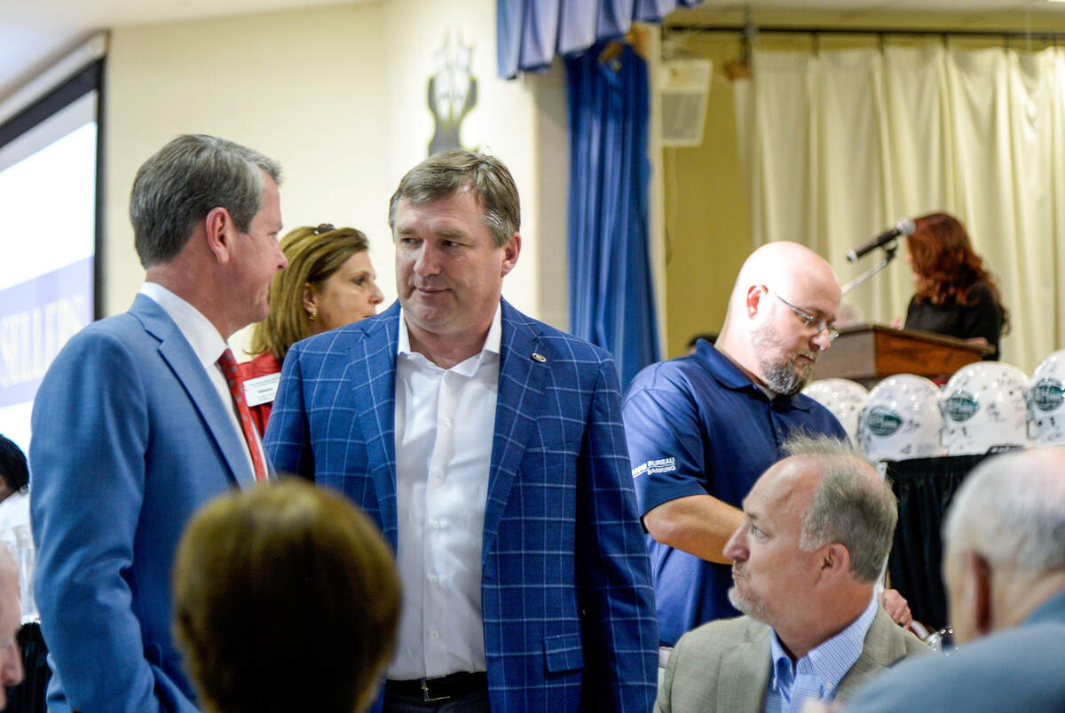 UGA football coach Kirby Smart (center) talks to Gov. Brian Kemp during the Macon Touchdown Club’s Jamboree Monday evening.