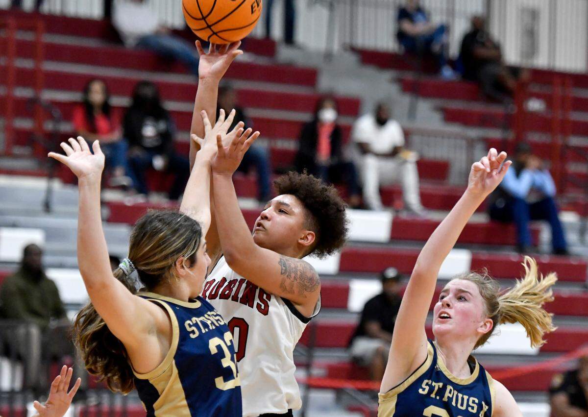 Warner Robins’ Jada Morgan (30) puts up a shot over St. Pius X defenders Friday night during the Demonettes’ 63-48 win in their second round state playoff game.
