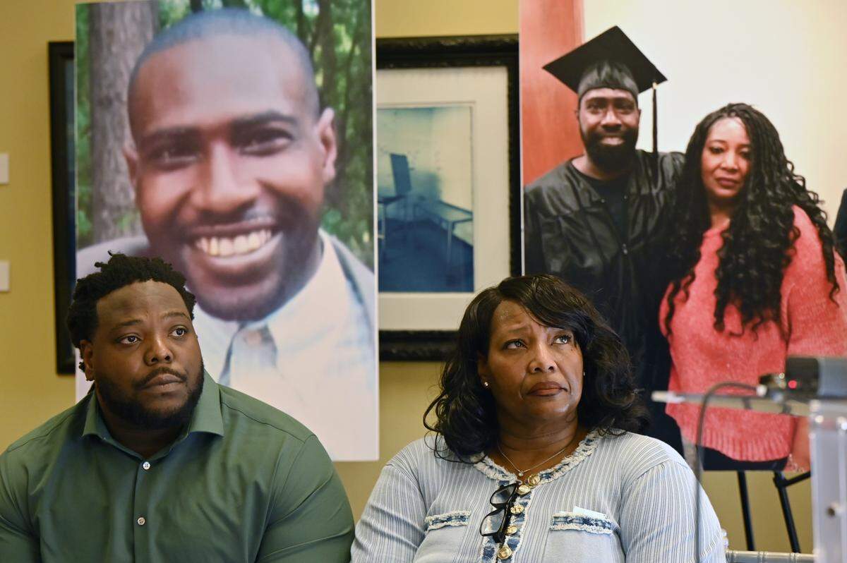 Posters of Stephen Fossett sit behind Fossett’s mother Paula Platt (right) and brother Keshawn Fossett during a press conference on the two lawsuits filed alleging systemic failures at the Bibb County Jail on Thursday, May 21, 2026, at the Tubman Museum in Macon, Ga. Attorneys at Davis Bozeman Law filed one federal lawsuit and one medical malpractice lawsuit against the Bibb County Sheriff’s Office after Stephen Fossett died in custody at the Bibb County Jail in May 2024.