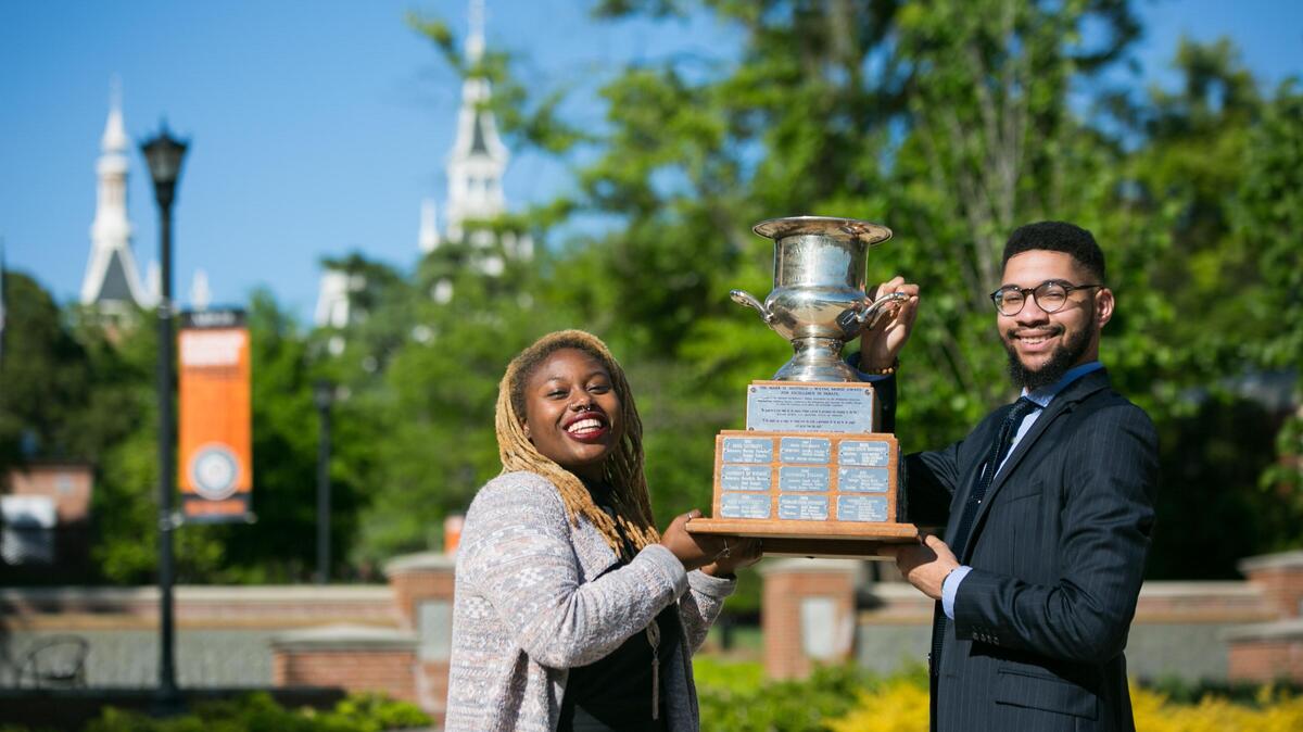 Mercer University seniors Jaz Buckley, left, and Kyle Bligen hold their first-place trophy from the National Parliamentary Debate Association National Championship Tournament on campus April 16.