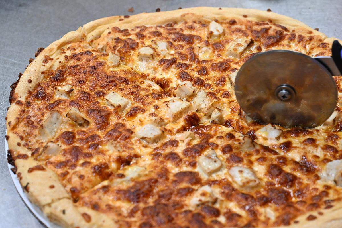 A buffalo chicken pizza is sliced into eighths at My Father’s Place during staff training on Tuesday, Aug. 19, 2025, in Warner Robins, Georgia. The buffalo chicken pizza is a new recipe that the new owners plan to add to the menu.