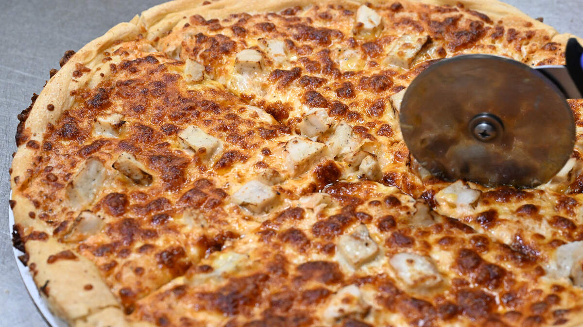 A buffalo chicken pizza is sliced into eighths at My Father’s Place in Warner Robins.