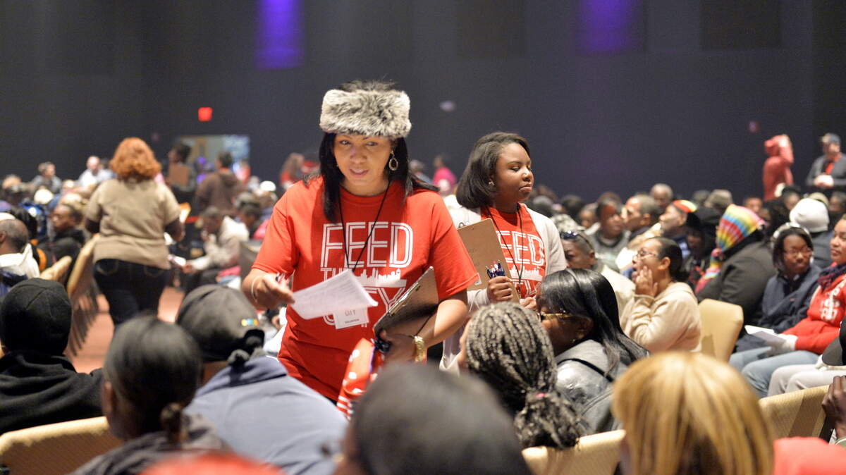 BEAU CABELL/THE TELEGRAPHVolunteer Soledad Vixen, left, helps a sea of needy army of 600 volunteers distributed turkeys and boxes of groceries at New Hope International Church in Warner Robins.