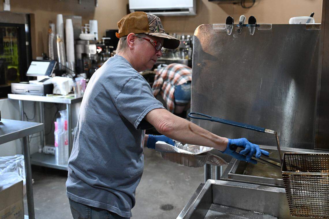 Tammy Simmons takes beignets out of the fryer before adding powdered sugar inside the kitchen of the new Little Light Coffee Co. location off Ga. 247 in Warner Robins.
